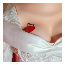 Load image into Gallery viewer, Doll is clothed with a white long sleeve wedding dress and black choker accessory. Has tattoo on right breast of a red heart with a dagger stabbed in it and the text "chucky" above the heart.