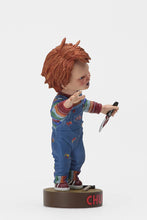 Load image into Gallery viewer, side of Head knocker bobble head of Chucky from Child&#39;s Play 2. Chucky has his right hand up, mouth open as if he is yelling, and in his left hand is clutching a knife. Chucky stands on a small round platform that reads &quot;CHUCKY&quot; in red letters on the front.
