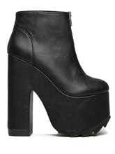 Load image into Gallery viewer, outer view of black vegan leather sleek 6.5" heel boot with silver front zip. Bottom of boot has a fanned front grip for better stability when walking.