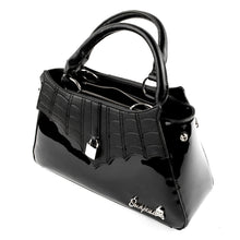 Load image into Gallery viewer, side view of Glossy black purse with silver lock detail on front center. The shell is comprised of glossy black faux leather, with matte leather stitched spiderweb details near the top. Zip closure, inner pockets and little metal feet.