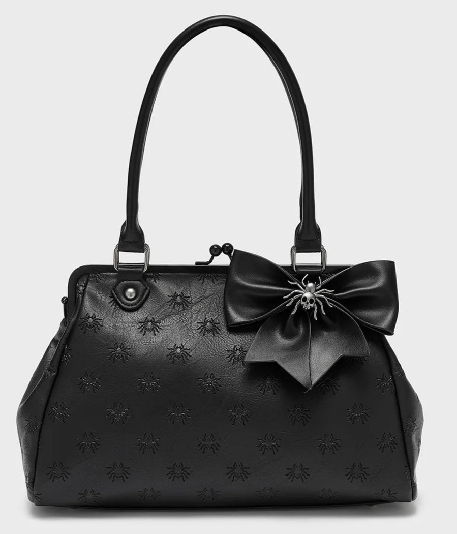 Black handbag with embossed spider pattern and bow on a white background