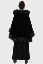 Load image into Gallery viewer, Model wearing a black faux fur-trimmed hooded cloak over a black dress on a white background
