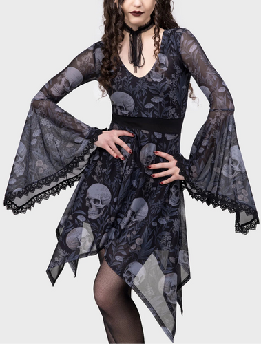 Woman wearing a black and white dress with skull and flower pattern on a white background