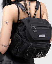 Load image into Gallery viewer, model wearing a black backpack with visible branding on a plain background
