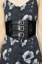 Load image into Gallery viewer, Model wearing a floral pattern dress with black corset-style belt on top
