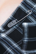 Load image into Gallery viewer, Close-up of a black and blue plaid fabric with a metal pin labeled &#39;&#39;IGIRL&#39;
