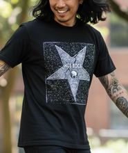 Load image into Gallery viewer, Person wearing a black t-shirt with a star design, walking outdoors on a sunny day.
