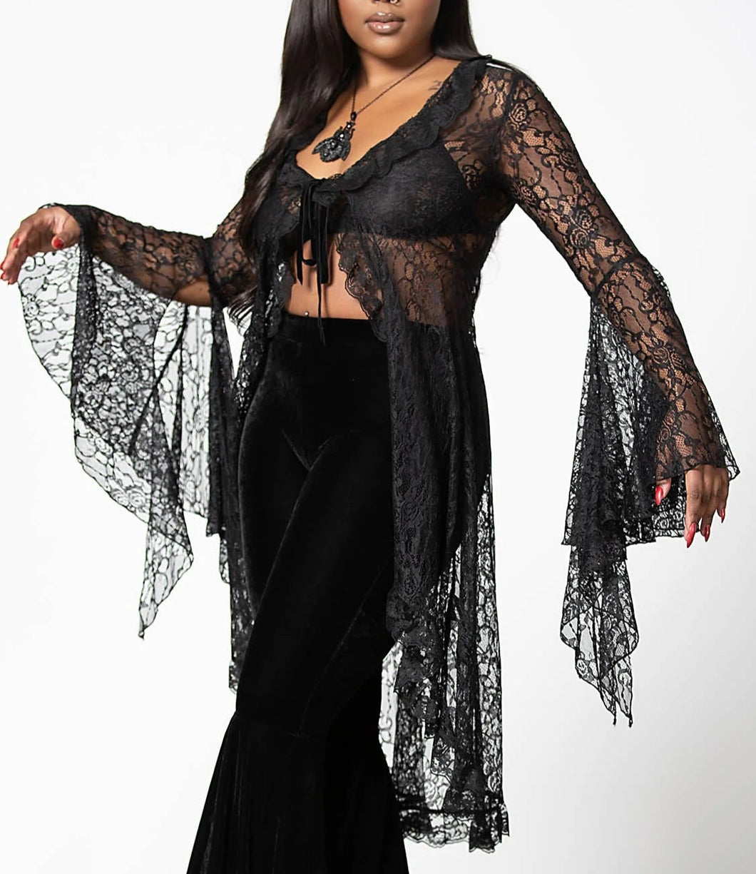 Model wearing a black lace top with a plain background