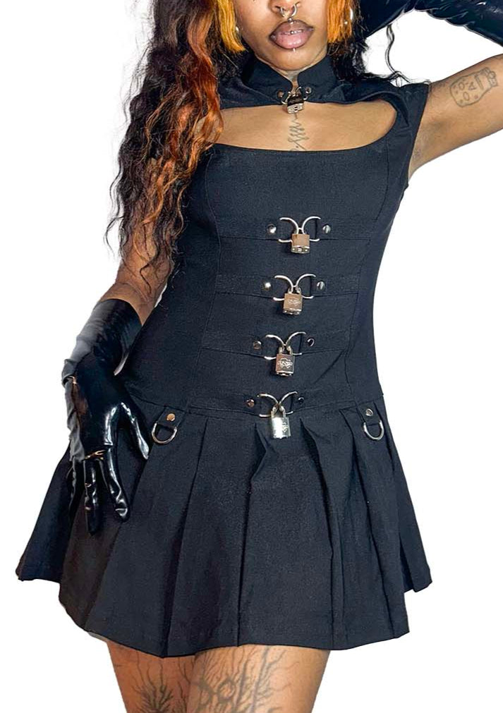 Model wearing black sleeveless dress with metal accents on a white background