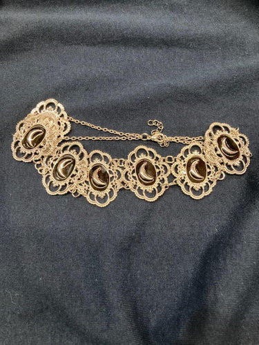 Brass colored multi crescent moon repeat pattern choker.