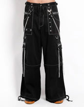 Load image into Gallery viewer, front view of Black baggy Tripp pants with white stitching. Pants have front rivet details, side pocket hanging chain details, removable attached chains, back zipper details and more. Pant legs can also zip off into shorts.
