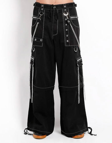 front view of Black baggy Tripp pants with white stitching. Pants have front rivet details, side pocket hanging chain details, removable attached chains, back zipper details and more. Pant legs can also zip off into shorts.