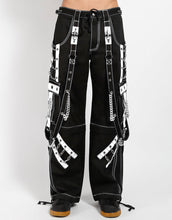 Load image into Gallery viewer, front of Black and white pants feature white stitching, removable straps, adjustable ankles, D-rings, clasps, and deep pockets.

