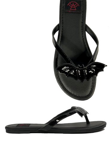 Black flat sandal with vegan leather patent bat on top.  Vegan leather with black rubber outsole.