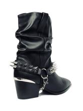 Load image into Gallery viewer, back side of Women&#39;s black vegan mid-calf pull on boot with attached black vegan leather bootstrap. Outer side of bootstrap has a silver O ring. Bootstrap has detachable silver chain that goes underneath boot. Front and back of boot strap have two rows of silver spikes. Black rubber outsole.
