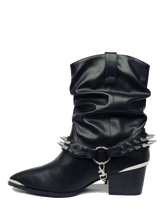 Load image into Gallery viewer, inner side of Women&#39;s black vegan mid-calf pull on boot with attached black vegan leather bootstrap. Outer side of bootstrap has a silver O ring. Bootstrap has detachable silver chain that goes underneath boot. Front and back of boot strap have two rows of silver spikes. Black rubber outsole.
