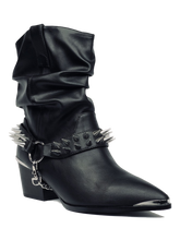 Load image into Gallery viewer, front side of Women&#39;s black vegan mid-calf pull on boot with attached black vegan leather bootstrap. Outer side of bootstrap has a silver O ring. Bootstrap has detachable silver chain that goes underneath boot. Front and back of boot strap have two rows of silver spikes. Black rubber outsole.
