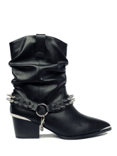 Load image into Gallery viewer, outer side of Women&#39;s black vegan mid-calf pull on boot with attached black vegan leather bootstrap. Outer side of bootstrap has a silver O ring. Bootstrap has detachable silver chain that goes underneath boot. Front and back of boot strap have two rows of silver spikes. Black rubber outsole.

