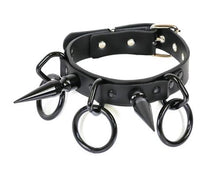 Load image into Gallery viewer, Black collar with large black D rings that have large black O rings hanging from them. Collar also has a black 3&quot; spike on each side.
