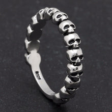 Load image into Gallery viewer, Silver band ring with multi-skull design.
