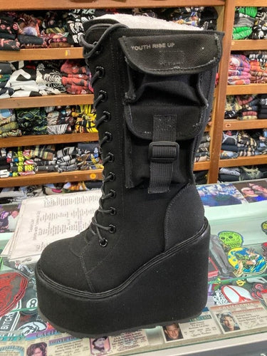 outer side of Women's black canvas mid-calf platform boot. Full lace up front, with full back zipper. Outside of boot has small pocket with strap.