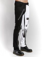 Load image into Gallery viewer, side of Classic slim White/Black split leg pants with removable bondage straps and zipper details. Pant legs can be zipped for a change in fit, topped off with a zip fly and button closure.
