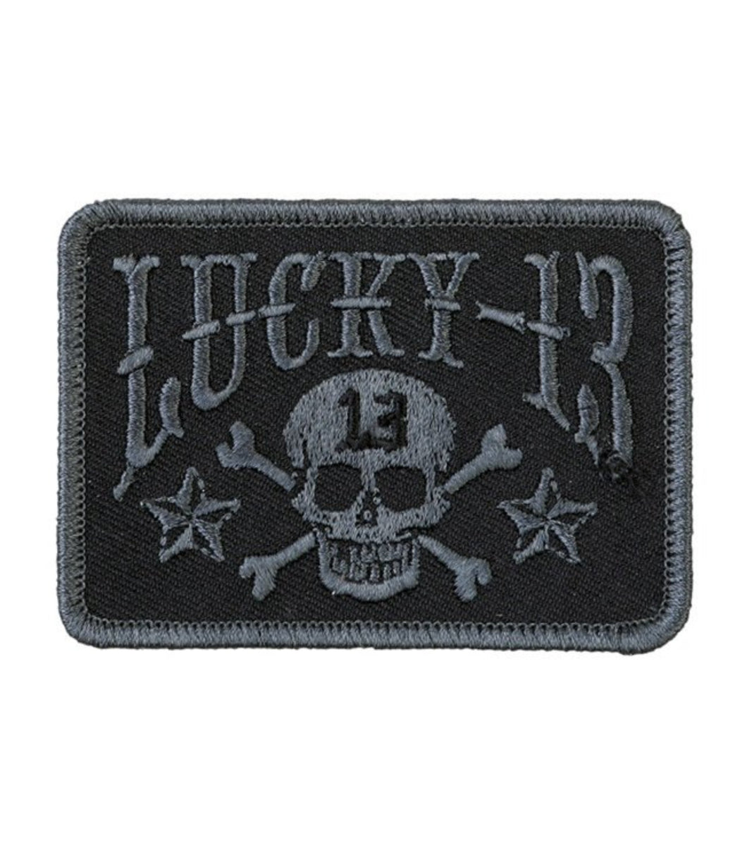 Fully embroidered black on black patch with skull and crossbones, stars, and Lucky 13 logo. 