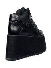 Load image into Gallery viewer, back view of black vegan leather platform shoe with EVA platform. Shoe looks like a sneaker, but super tall! Shoe has nylon details and mesh lining. Bottom of platform has a &quot;fanned&quot; grip to make the platform more stable.
