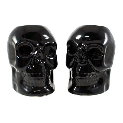 Black skull candlestick holders come in a set of two, and each holds a standard taper candle. CANDLES NOT INCLUDED.