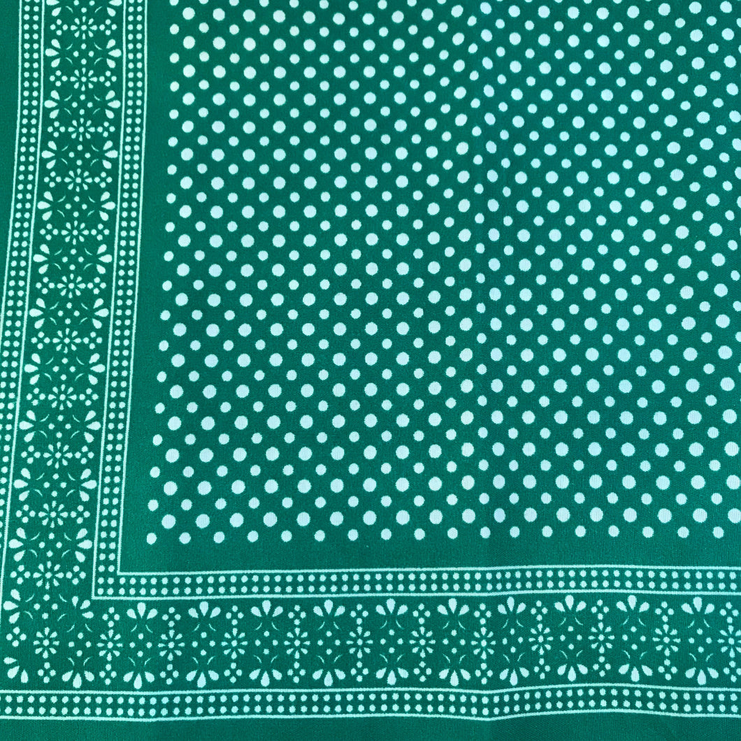 Green bandana with white polka dots pattern.