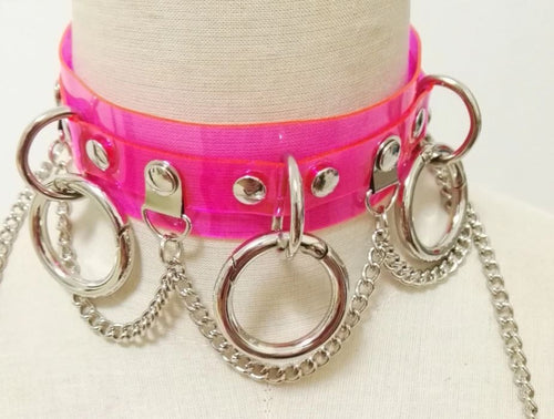 front view of neon pink see-through choker with Three O rings with Hanging chain and Adjustable buckle closure