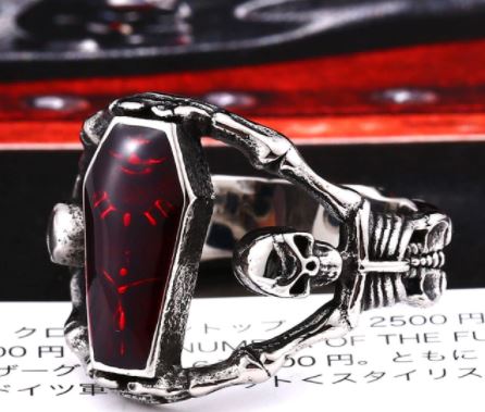 silver colored coffin ring with skeleton band