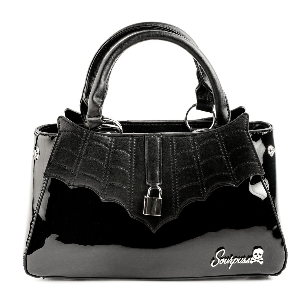 front view of Glossy black purse with silver lock detail on front center. The shell is comprised of glossy black faux leather, with matte leather stitched spiderweb details near the top. Zip closure, inner pockets and little metal feet.