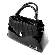 Load image into Gallery viewer, side view of Glossy black purse with silver lock detail on front center. The shell is comprised of glossy black faux leather, with matte leather stitched spiderweb details near the top. Zip closure, inner pockets and little metal feet.
